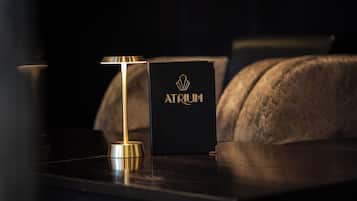 A black box with "Atoium" written on it, placed on a dark surface next to a lamp.