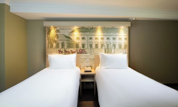 Experience the charm of a city street scene in this unique room, featuring a large mural and two single beds with comfortable linens.