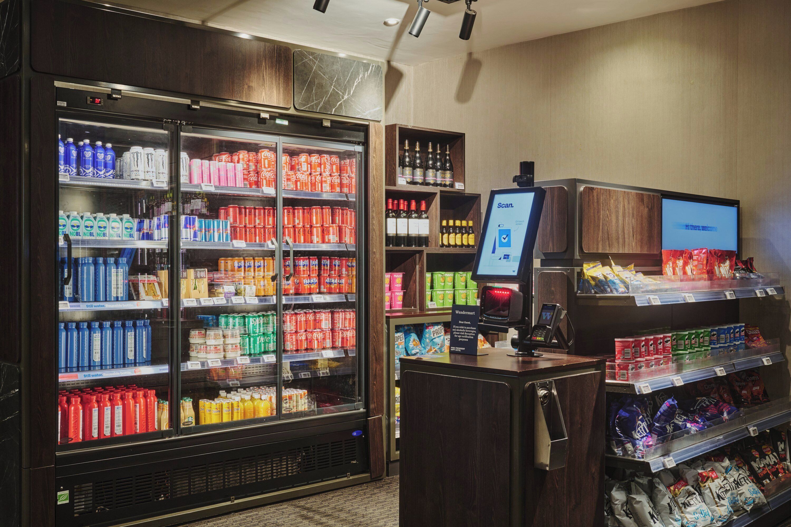 Un distributeur automatique de boissons en libre-service, doté de présentoirs réfrigérés et d’étagères pour les en-cas.