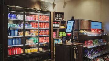 A self-service beverage kiosk with refrigerated beverage dispensers and snack shelves.