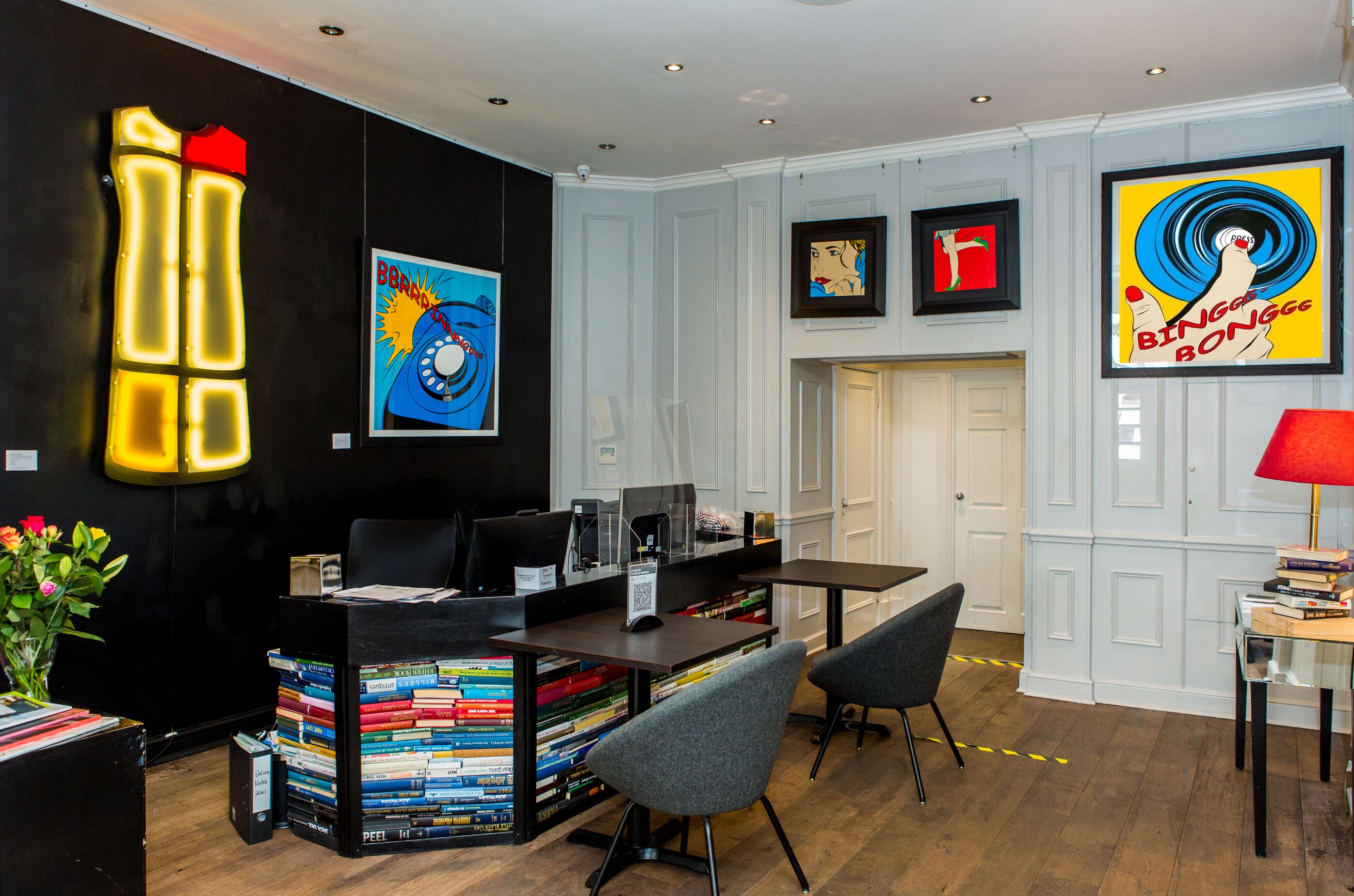 A modern library with bookshelves, a desk, and a comfortable seating area.