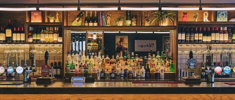 A bar area with multiple liquor bottles, a variety of glasses, and a selection of beer taps.