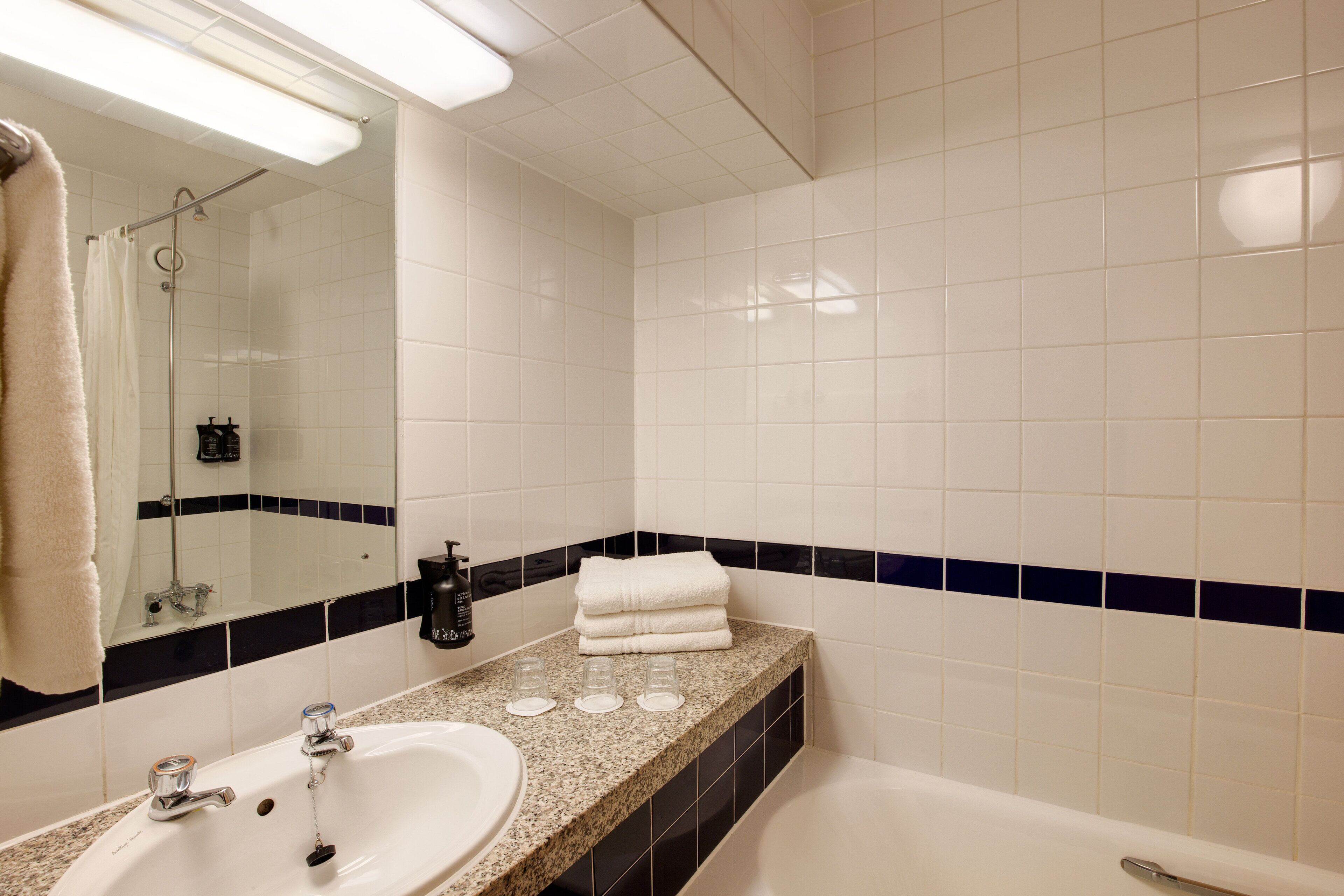 Un bagno con lavandino, specchio e vasca da bagno.