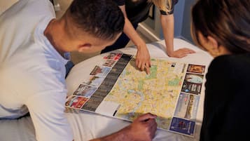 A group of people examining a large map on a bed.