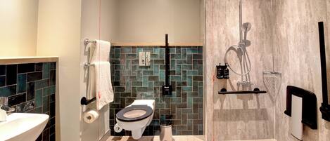 A modern bathroom with a toilet, sink, and shower.