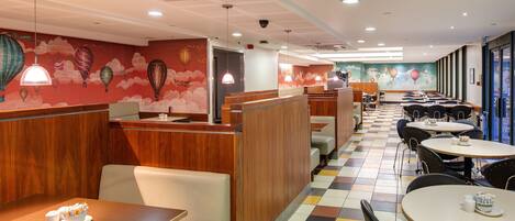 A restaurant with booths and tables, a check-in counter, and a colorful mural on the walls.