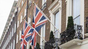 A row of terraced houses with a prominent British flag and a blue awning with "The Leonard London" sign.