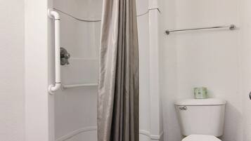 Un petit espace douche fermé, équipé de toilettes et d’un porte-serviettes.