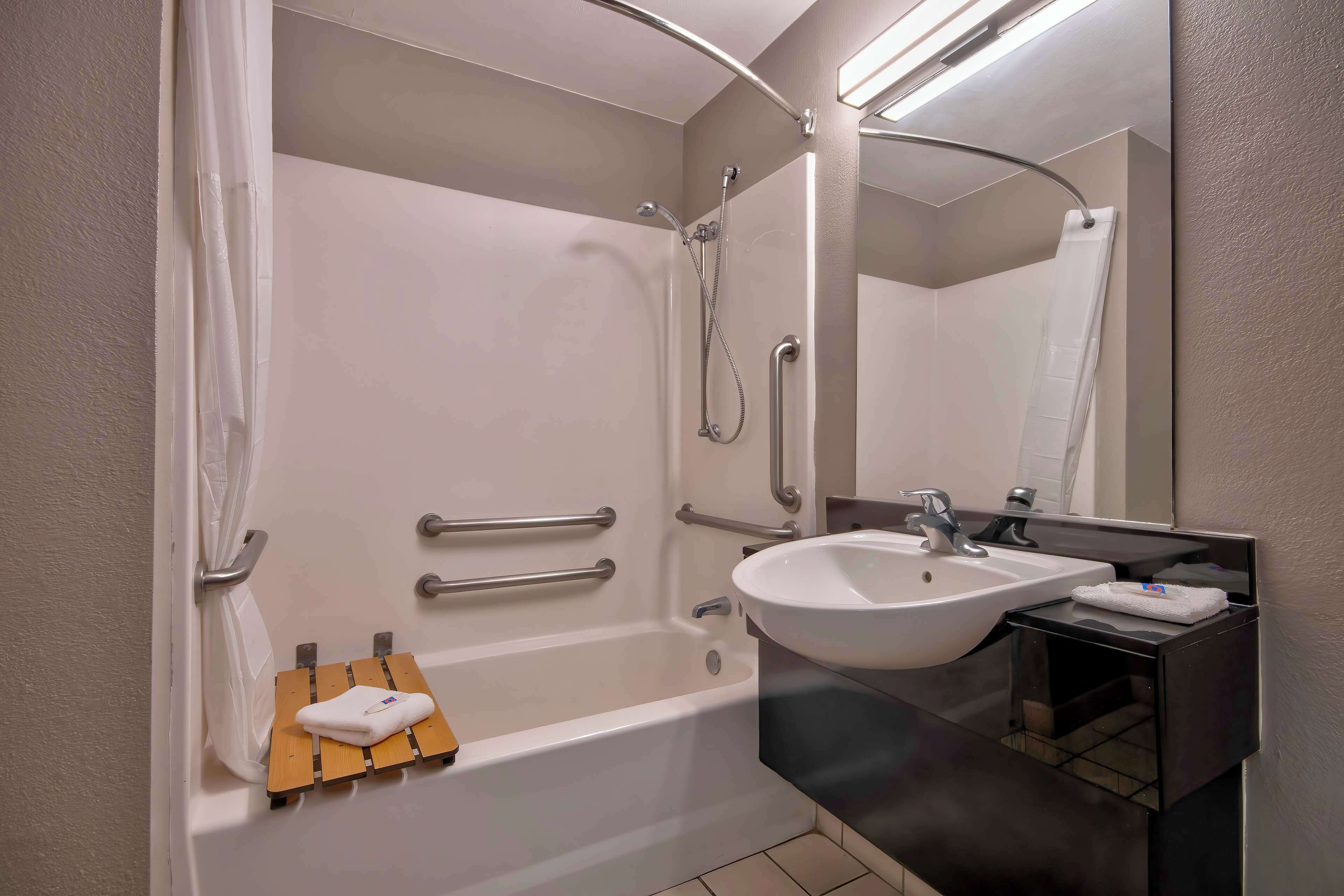 Un bagno moderno con una vasca, un lavandino e uno specchio.