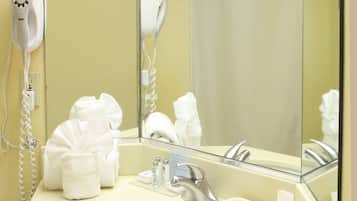 A bathroom with a sink, mirror, towel rack, and a hairdryer.
