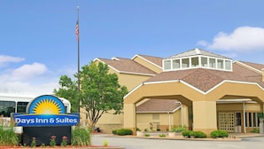 A Days Inn & Suites building with a prominent sign, a flagpole with an American flag, and a parking lot.
