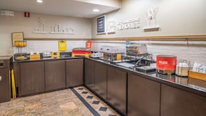 Un buffet pour le petit-déjeuner proposant une variété d’aliments, avec une pancarte indiquant : « Commencez votre journée en beauté avec un délicieux petit-déjeuner. »