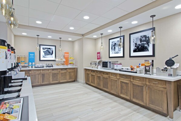 A modern kitchen with wooden cabinets, a white countertop, and various appliances like a microwave and toaster. - Hampton Inn Sault Ste Marie (Sault Ste. Marie)