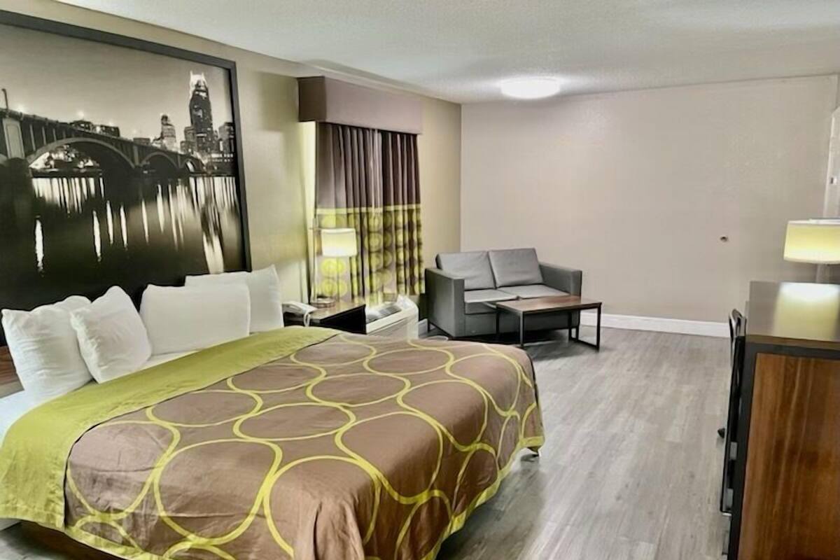Une chambre d’hôtel avec un grand lit, un canapé, un bureau et une chaise.