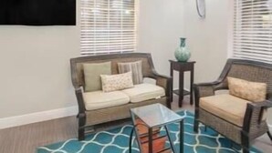 Un salon comprenant un canapé, une table basse et un tapis à motifs.