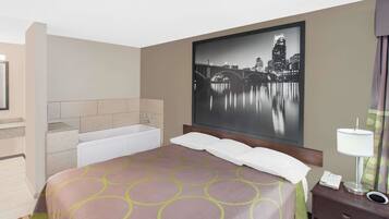 A hotel room with a bed, a nightstand, a lamp, a telephone, and a large cityscape painting on the wall.