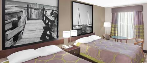 Habitación de hotel con dos camas, una mesita, una silla y un cuadro grande con un muelle y veleros.