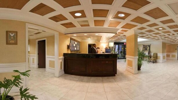 A hotel lobby with a reception desk, a high ceiling with wooden panels, and a tiled floor. - Holiday Inn Express Ringgold by IHG (Ringgold)
