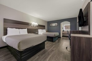 A hotel room with a large bed, a smaller bed, a desk, and a TV. - Quality Inn Gadsden – Attalla (Gadsden)