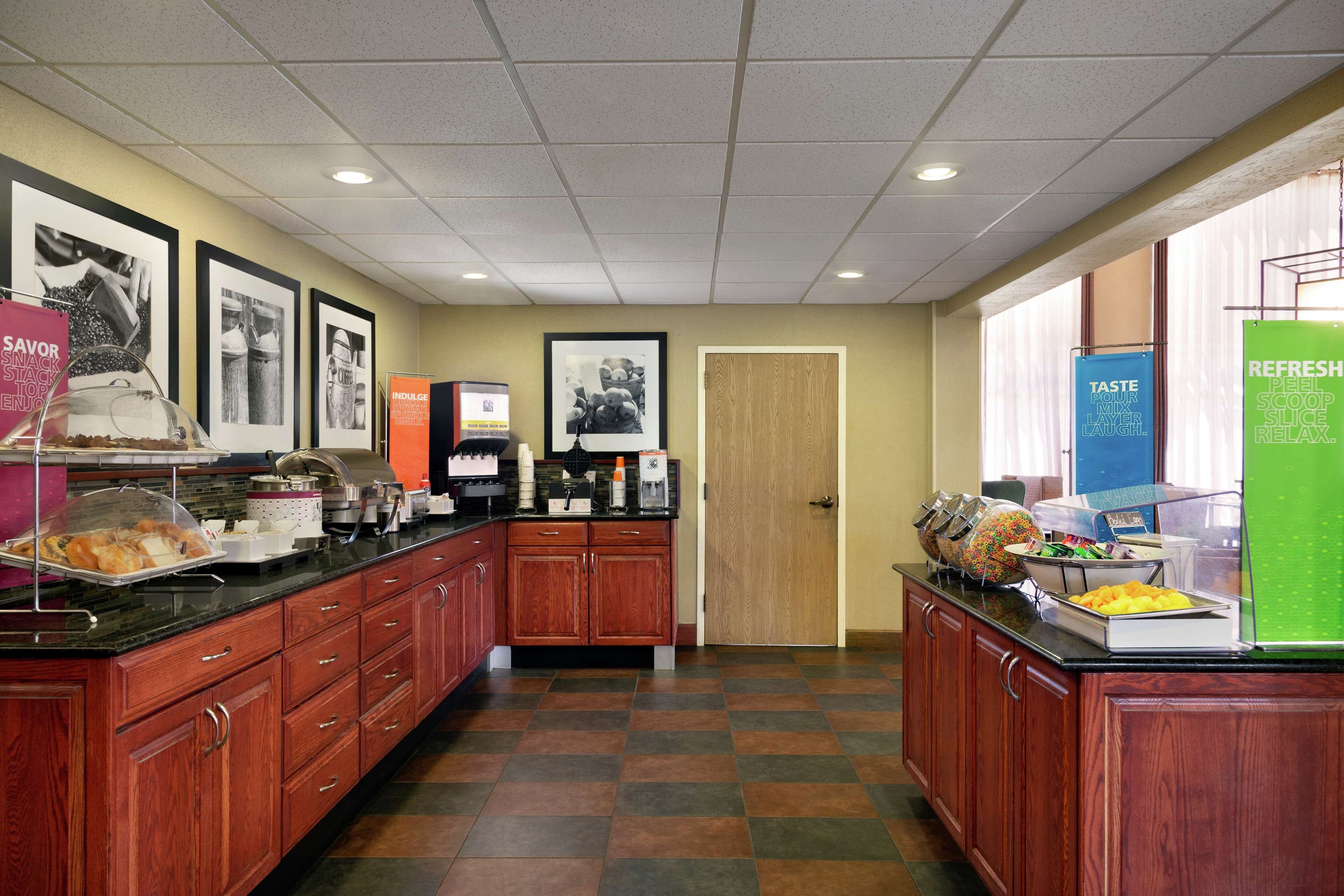 Een keukengedeelte met een buffetopstelling, inclusief een koffiehoek en diverse etenswaren gepresenteerd op het aanrecht.