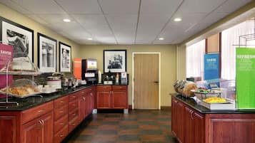 A kitchen area with a buffet setup, including a coffee station and various food items displayed on the counter.