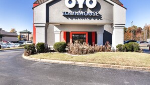 The exterior of the OYO Townhouse, featuring a modern design with a prominent entrance and a clear view of the parking area.