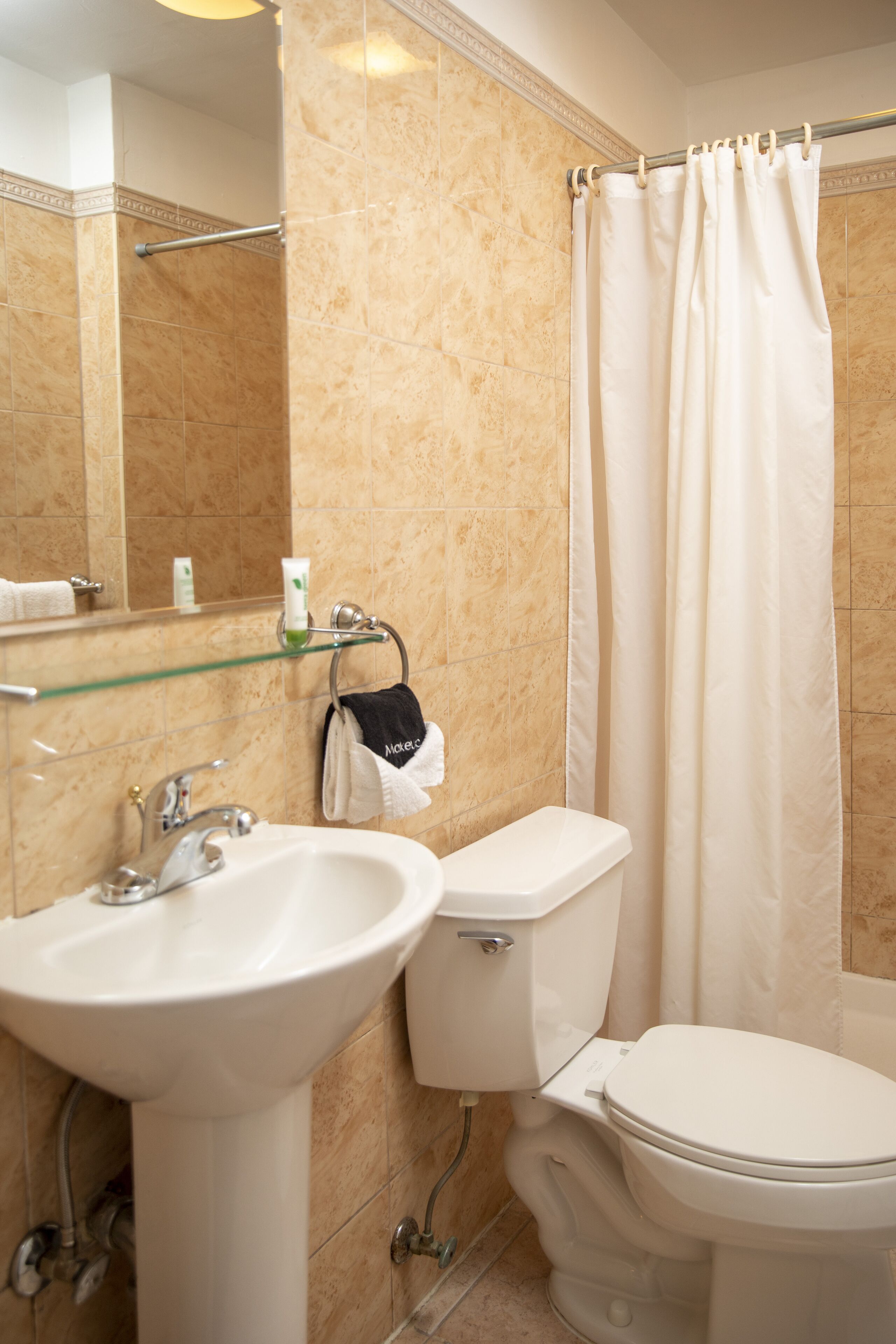 A bathroom with a sink, toilet, and shower curtain.