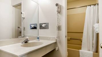 A bathroom with a sink, mirror, towel rack, and a shower curtain.