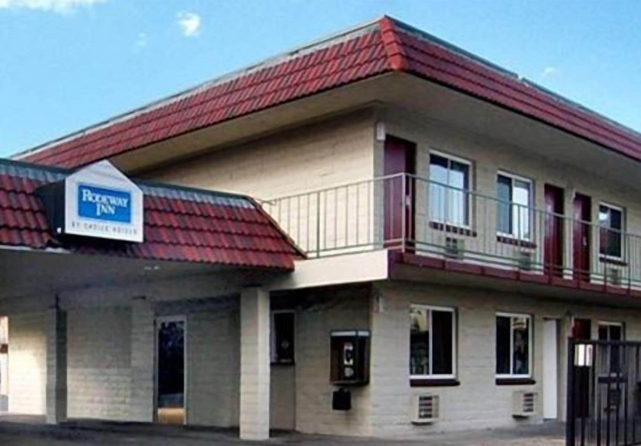 A two-story motel with a red roof and a sign indicating it is a Roadway Inn.