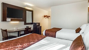 A hotel room with two beds, a desk, a chair, a TV, and a microwave. - Rodeway Inn Wine Country (Rohnert Park)