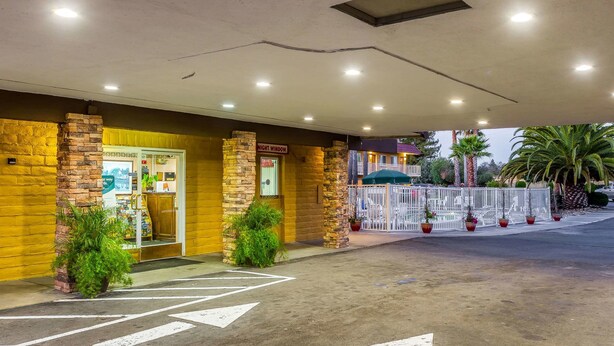 A hotel entrance with a brick facade, a night window, and a gated driveway. - Rodeway Inn Wine Country (Rohnert Park)