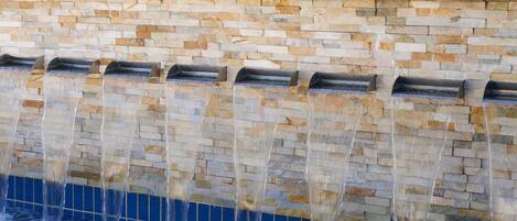 A stone wall with multiple water features.