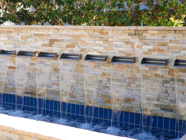 Un muro de piedra con varias fuentes de agua.