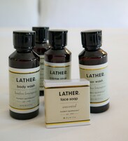 Cuatro botellas de jabón corporal Lather y una caja de jabón facial.