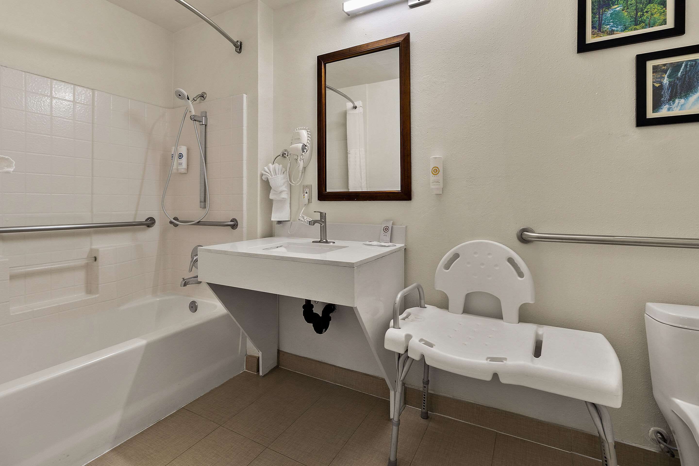 Une salle de bain avec une baignoire, un lavabo, un miroir et des toilettes.
