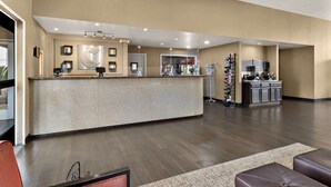 A modern reception area with a counter, seating, and a kitchen in the background. - Comfort Inn & Suites Sequoia/Kings Canyon (Three Rivers)