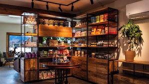 A well-organized retail space with shelves stocked with various products, a central wooden table, and a potted plant. - Boundary Hotel By Terra Vi Durango (Durango)