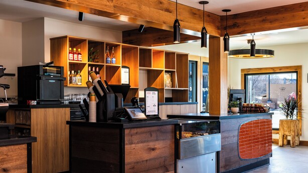 A modern bar area with wooden accents, a coffee machine, and a menu board. - Boundary Hotel By Terra Vi Durango (Durango)