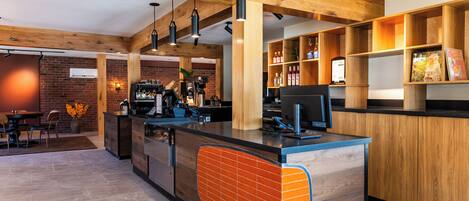 Un espacio de bar moderno con vigas de madera, una barra con salpicadero de azulejos y estantes con botellas y libros.