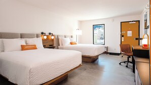 A hotel room with two beds, a desk, a chair, a lamp, and a door. - Boundary Hotel By Terra Vi Durango (Durango)