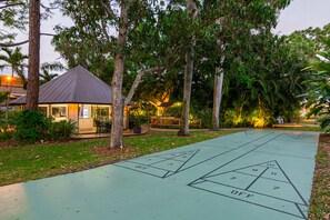 A shuffleboard court with a house and trees in the background. - Fairways Inn of Naples (Naples)