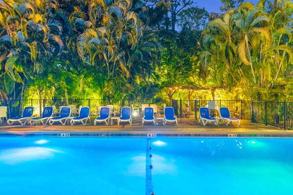 Una piscina al aire libre, una piscina climatizada, sombrillas