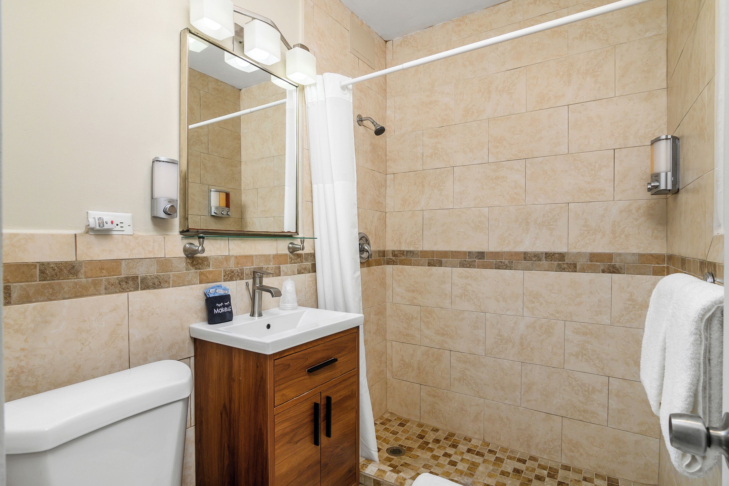 A modern bathroom with a shower, toilet, and vanity.