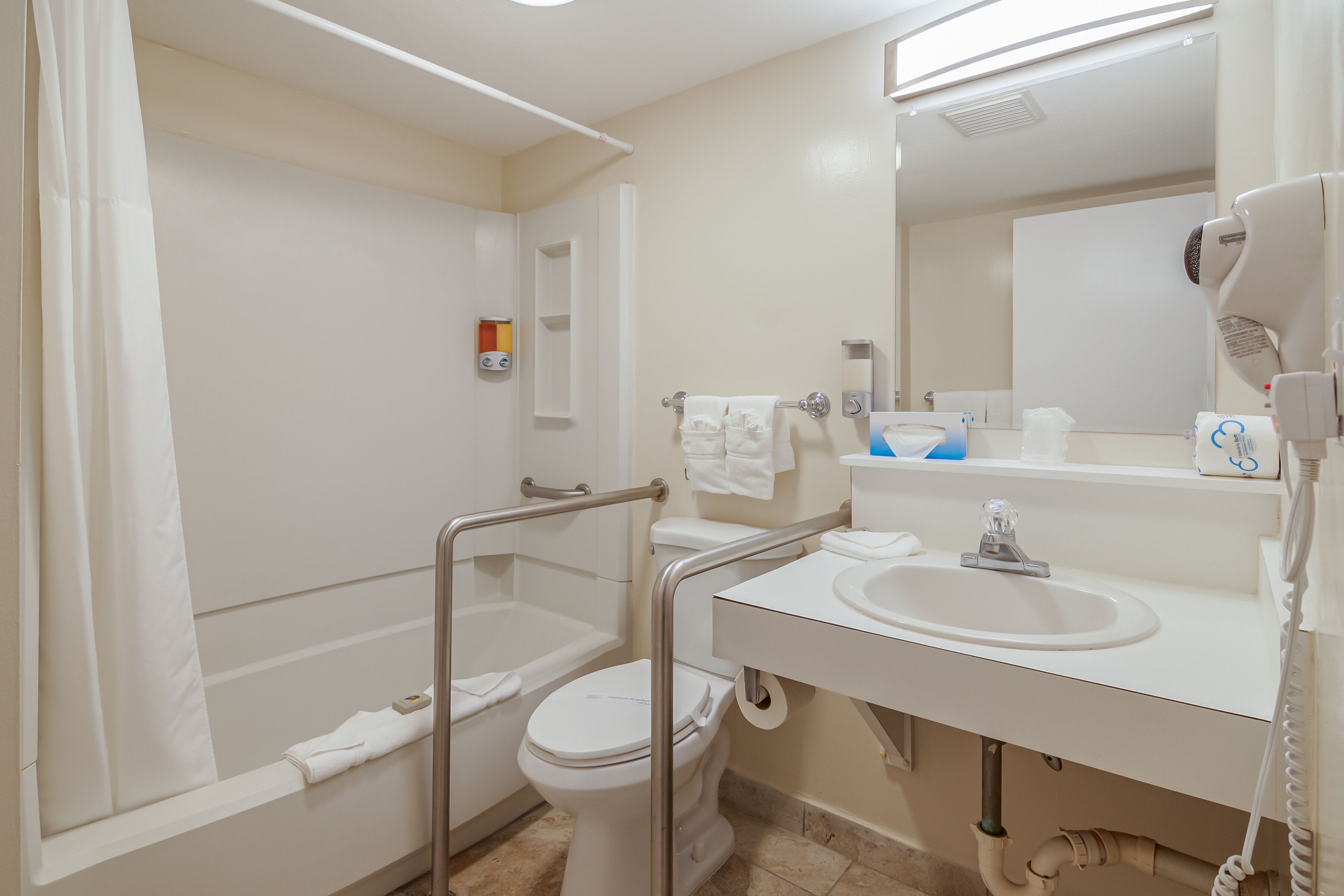 Un baño con ducha, inodoro, lavabo y secador de pelo.