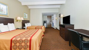 A hotel room with two beds, a desk, a television, and a bathroom visible through an open door. - Americas Best Value Inn Sarasota Downtown (Sarasota)