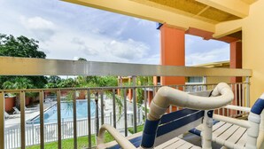 A balcony with a view of a pool and palm trees. - Americas Best Value Inn Sarasota Downtown (Sarasota)