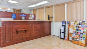A reception area with a wooden counter, a bulletin board, and a magazine rack. - Americas Best Value Inn Sarasota Downtown (Sarasota)
