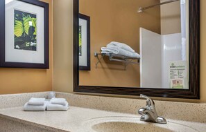 A bathroom with a sink, a framed picture, a towel rack, and a mirror.