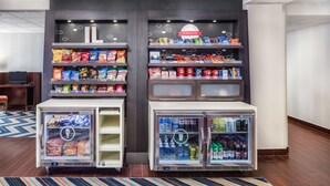 A beverage fridge with snacks and drinks, a small TV, and a patterned rug. - Hampton Inn Joliet-Plainfield I-55 (Joliet)