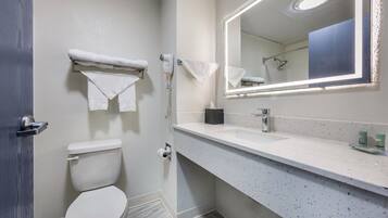 Een moderne badkamer met een wit toilet, een wastafel met spiegel en een handdoekrek.